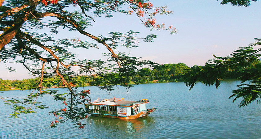 Take a boat for a cruise on the gentle Huong River