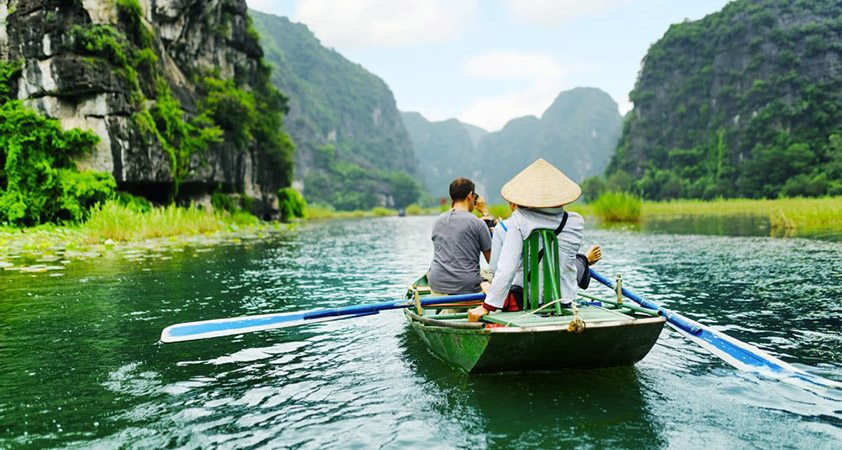 Sitting on the boat, flowing peacefully along Ngo Dong river, visitors will truly immerse in the natural scenery of Tam Coc, Bich Dong